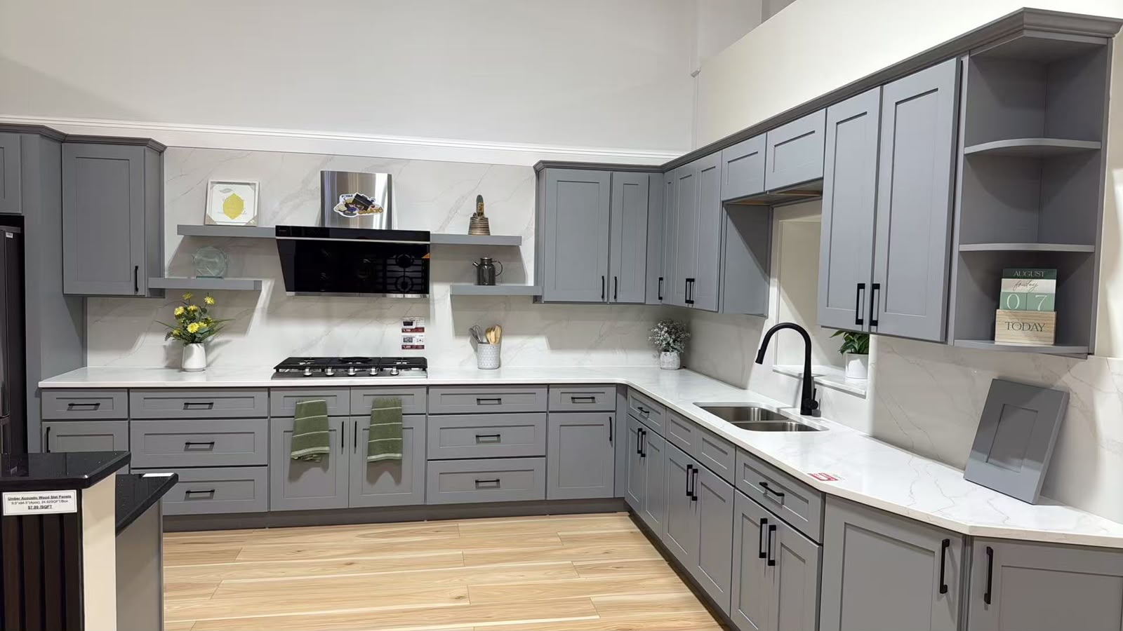 Light grey Shaker kitchen on display in the showroom with a quartz counter and marble effect backsplash