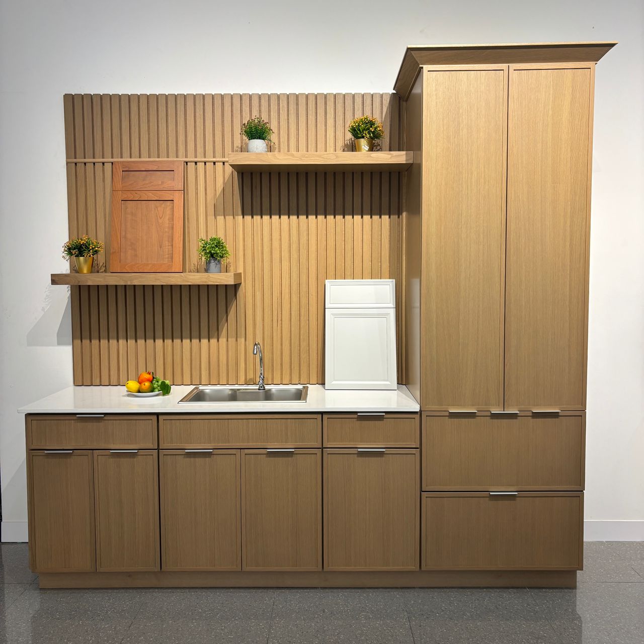 Natural oak Shaker cabinets on display in our showroom with a tall pantry