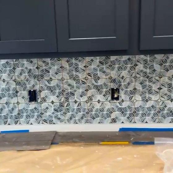 Mosaic backsplash cut in against wall cabinets