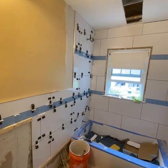 Tiled bathroom wall with the window trimmed in