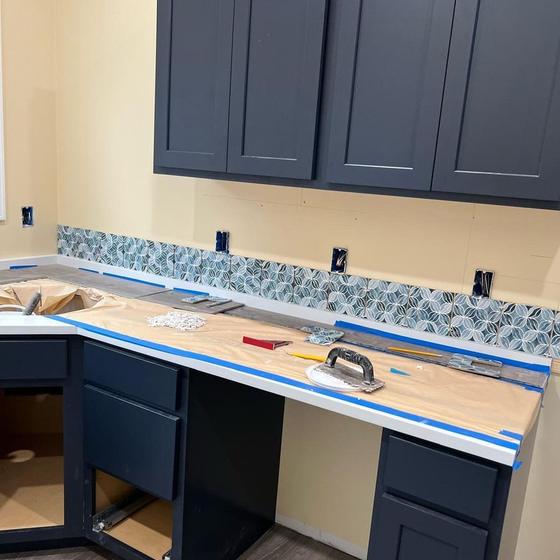 Navy cabinets, quartz counter and backsplash trimmed out