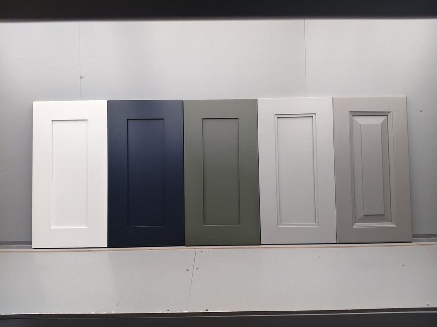 Five cabinet door samples in white, navy, sage green, grey and a raised panel